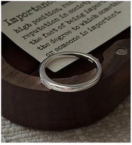 Macro shot of minimalist S925 sterling silver ring with rectangular zircon on wood