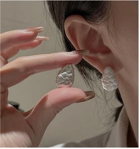 Detailed view of matte silver S925 earrings with intricate braided drop-shape texture