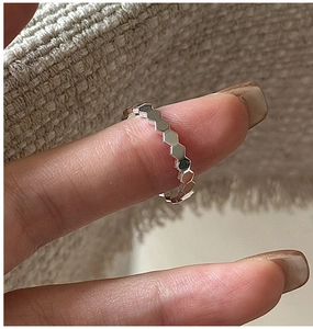 Close-up of hexagonal honeycomb design silver ring with high-polished metallic finish