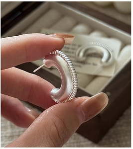Close-up of S925 sterling silver hoop earrings with matte finish and textured edges