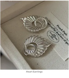 Detail of vintage heart-shaped silver earrings with pleated texture in a jewelry box