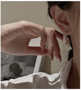 Close-up of S925 sterling silver hoop earrings with textured spiral thread finish