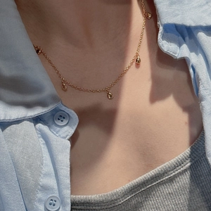 Collier minimaliste en argent S925 doré avec pendentifs goutte porté par un mannequin