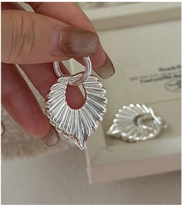 Detail view of silver S925 sterling silver hollow fan earrings with radial texture