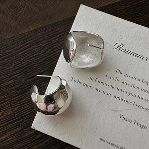 Elegant S925 sterling silver C-shaped earrings with irregular hammered texture on wood