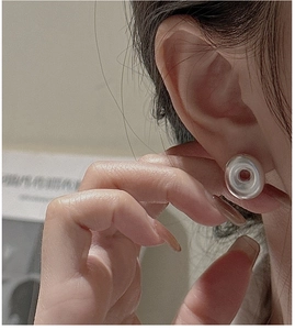 Close-up of S925 sterling silver hollow hoop earrings in a glossy doughnut shape on ear