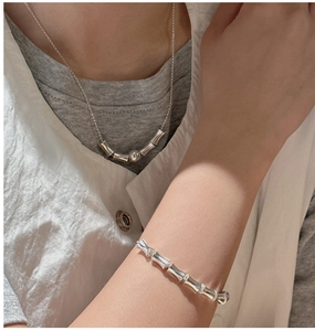 Detail of 925 sterling silver bamboo style necklace and bracelet on a female model