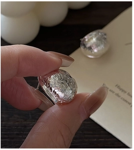 Macro shot of S925 sterling silver earrings with textured hammered finish detail