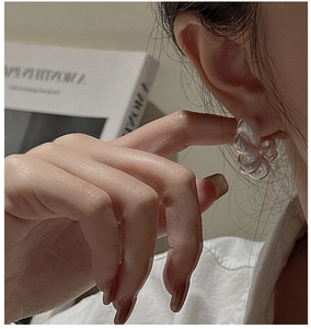 Close-up of translucent matte earrings featuring a retro twisted hollow design