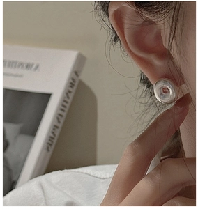 Close-up of model wearing a minimalist silver hollow hoop earring with a polished finish