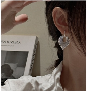 Close-up of S925 sterling silver fan-shaped earrings with elegant pleated metal texture