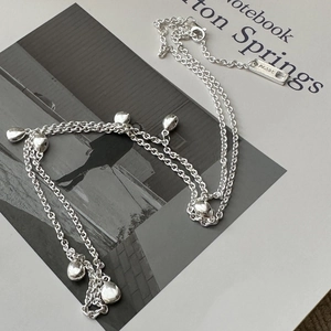 Collier minimaliste en argent sterling S925 avec pendentifs gouttes sur un carnet