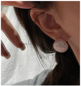 Close-up of S925 silver rose gold round stud earrings with intricate mesh texture