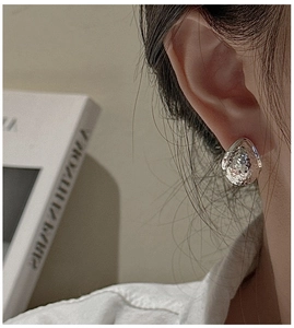 Macro shot of silver teardrop earrings with hammered texture and vintage finish