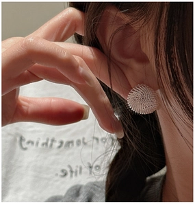Close-up of S925 sterling silver earrings with beaded mesh texture on model ear