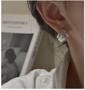 Detailed view of silver water drop earrings with hand-hammered texture on model