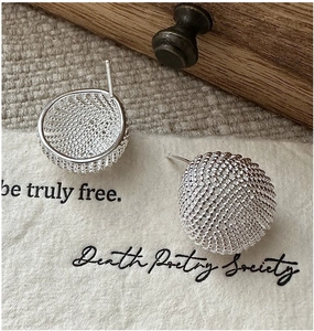 Macro detail of S925 sterling silver stud earrings with woven mesh texture and vintage design