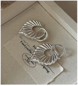 Close-up of S925 sterling silver hollow earrings with elegant fan-shaped pleated texture