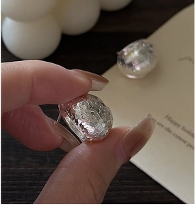 Detail of irregular S925 sterling silver stud earrings with textured hammer finish