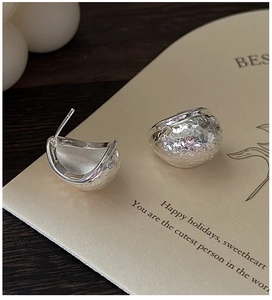 Macro shot of S925 sterling silver earrings with textured hammered finish on card