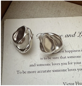 Macro detail of S925 sterling silver teardrop earrings with irregular matte lava texture