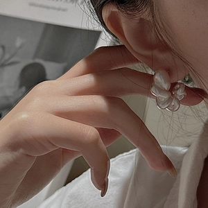 Elegant 925 sterling silver white flower stud earrings with pearl luster on female model
