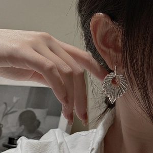 Elegant S925 sterling silver hollow fan leaf earrings shown on a female model