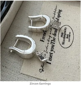 Macro shot of S925 sterling silver U-shaped earrings with square-cut sparkling zircon stones