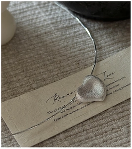 Macro detail of S925 silver heart pendant showing unique brushed metal texture finish