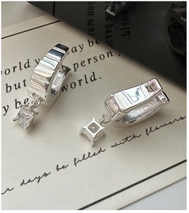 Close-up of S925 silver hoop earrings with square zircon and wavy textured surface