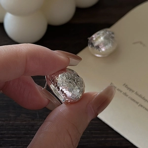S925 sterling silver dome earrings with hammered texture held in hand for scale