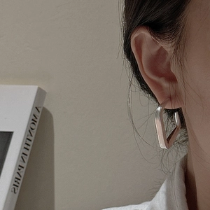 Boucles d'oreilles créoles géométriques minimalistes en argent 925 portées par un mannequin