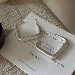 Boucles d'oreilles carrées minimalistes en argent 925 mat présentées sur une carte