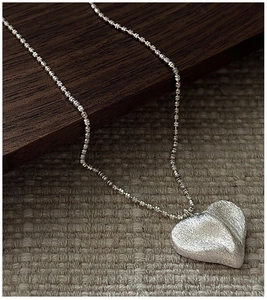 Détail du collier coeur en argent S925 avec texture givrée et chaîne à billes fine