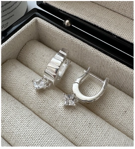 Close-up of S925 sterling silver earrings with ribbed hoops and square-cut zircon stones