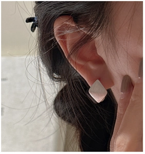 Close-up of S925 sterling silver geometric rhombus earrings with brushed metal finish