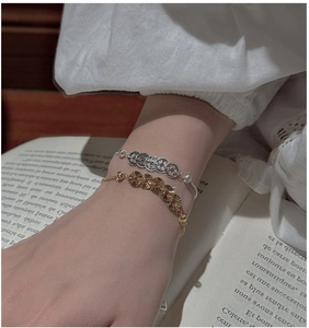 Detail von Silbermünzen-Armband und Goldsonnen-Armband mit verstellbarem Verschluss