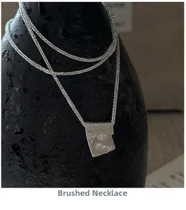 Detailed close-up of a brushed S925 silver pendant necklace with a round quartz stone