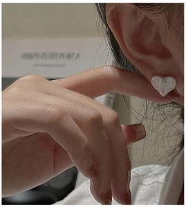 Close-up of heart-shaped S925 sterling silver stud earring with brushed metal finish