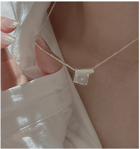 Close-up of S925 silver necklace with white pearl pendant worn on a minimalist collarbone