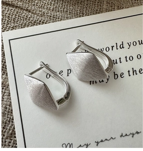 Macro view of minimalist S925 silver rhombic hoop earrings with brushed matte finish