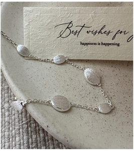 Detail of minimalist S925 sterling silver beaded bracelet with brushed matte finish