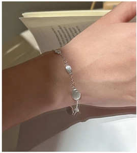 Close-up of minimalist S925 silver bracelet featuring irregular brushed metal charms