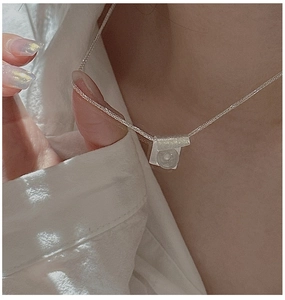 Detail of S925 silver brushed pendant with white crystal bead on a delicate chain