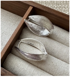 Macro shot of S925 sterling silver hoop earrings with natural bark texture and vintage finish