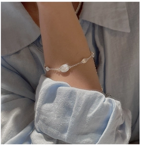 Detail of S925 sterling silver bracelet featuring brushed hammered oval metal charms
