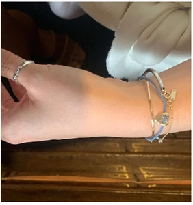 Close-up of layered S925 silver bracelet with heart charm and minimalist chain rings