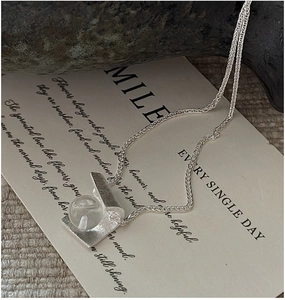 Detail of S925 sterling silver brushed geometric necklace with clear crystal pendant