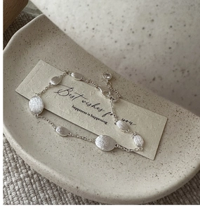 Detail of S925 sterling silver brushed chain bracelet with a sparkling zircon pendant