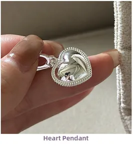 Vue rapprochée du pendentif cœur en argent avec bordure perlée de style rétro